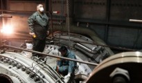 Public Power Corporation's employees repair a gas turbine compartment inside a power station at Lavrio town southeast of Athens