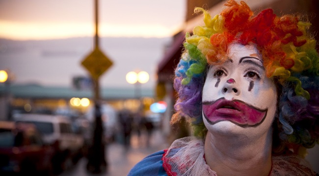 A young girl dressed up as a clown.