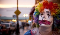 A young girl dressed up as a clown.