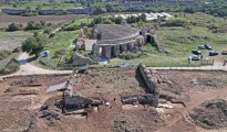 Εικ. 2. Το οικοδόμημα από δυτικά κατά τη διάρκεια των ανασκαφών. Σε πρώτο πλάνο το υπό ανασκαφή οικοδόμημα, σε δεύτερο πλάνο το Ωδείο στο βάθος του ορίζοντα ο Αμβρακικός κόλπος