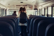 Energetic pupils leave academic shuttle. Friendly crowd go out school bus. Diverse multicultural students running out vehicle after studies. Professional driver sitting alone. Transport concept.